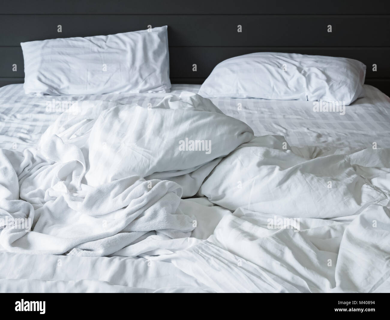 messy white bedding sheets and pillow in bedroom background ,Unmade messy bed after comfort sleep concept Stock Photo
