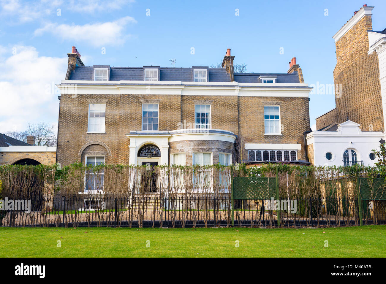 Clapham London, UK - January 2018: Facade of an opulent restored Victorian house luxury mansion in yellow bricks and white finishing with private gard Stock Photo
