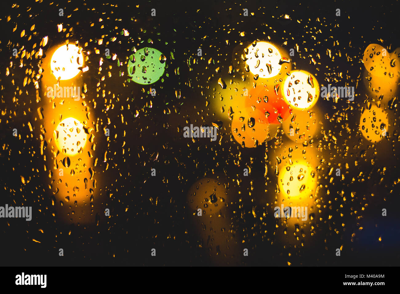 Rain drops on window. Peaceful evening or night at home when raining outside. Water drops on glass. Surface of wet glass. Water splash. City lights bo Stock Photo