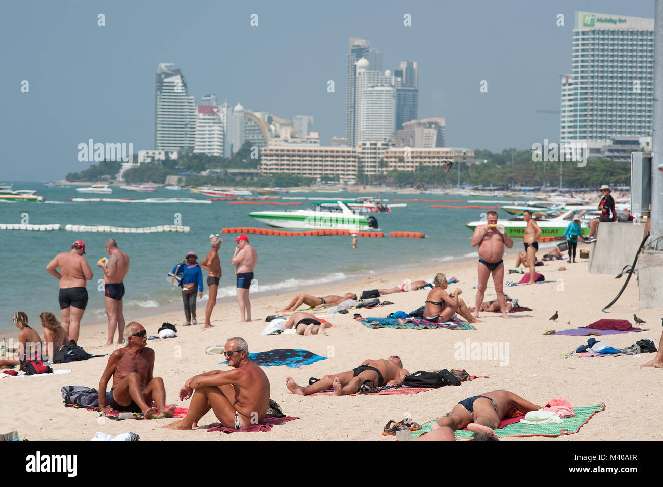 Tourists Sunbathing on Pattaya Beach Thailand Stock Photo