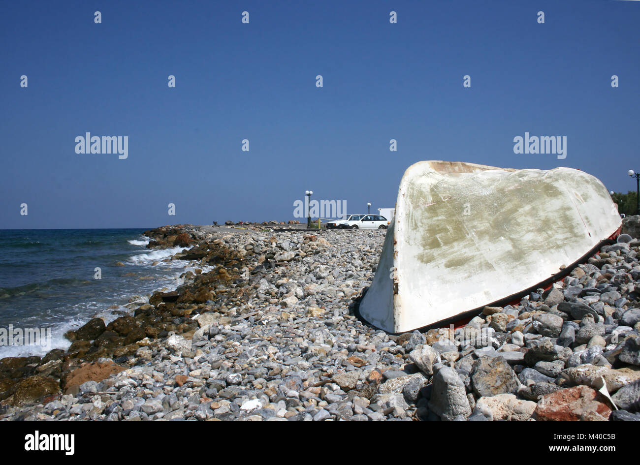 An upturned fishing boat of fibreglass construction on a pebble beach ...