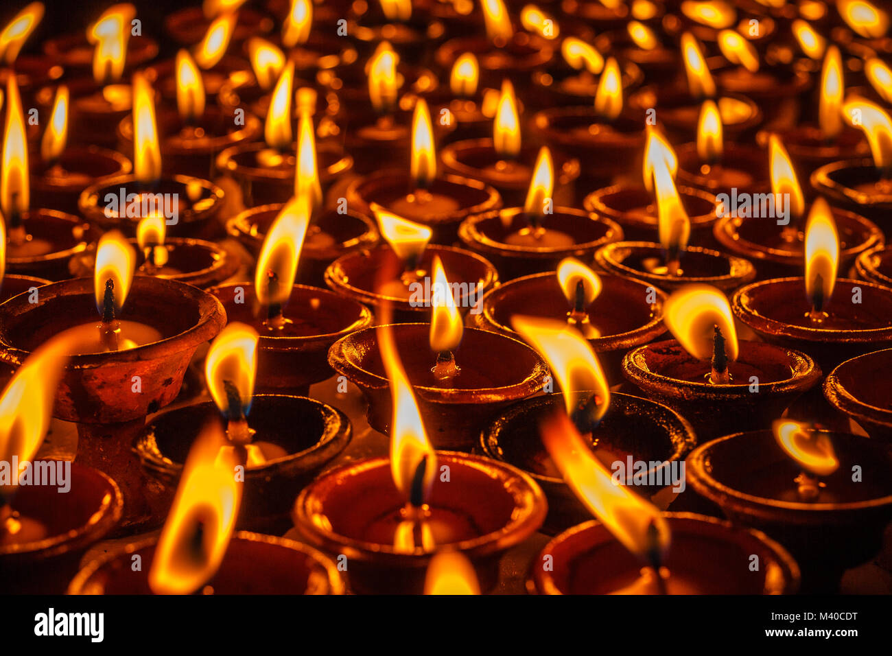 Oil lamps for the evening prayers burning at Boudhanath stupa, Kathmandu, Nepal. Stock Photo