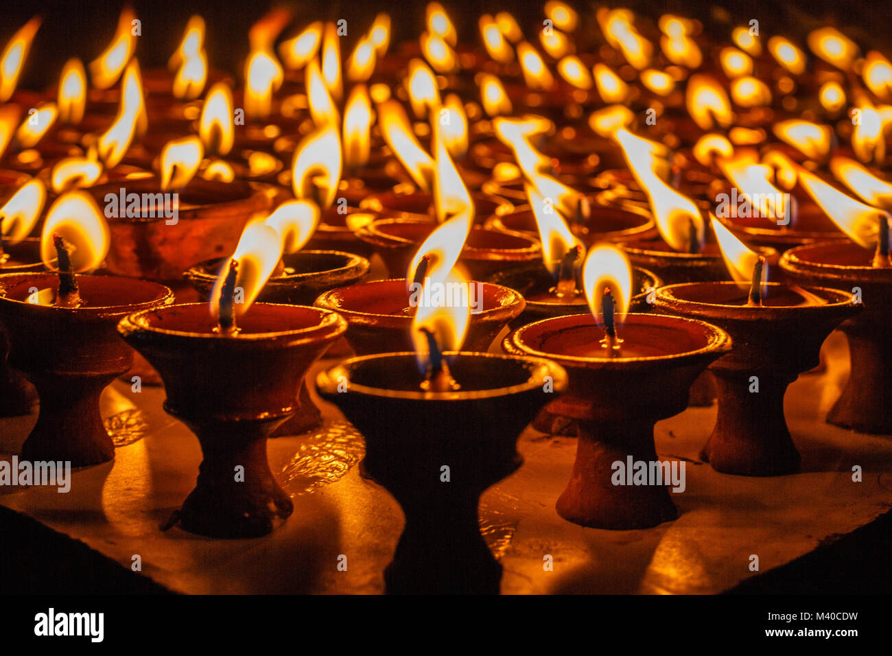 Oil lamps for the evening prayers burning at Boudhanath stupa, Kathmandu, Nepal. Stock Photo