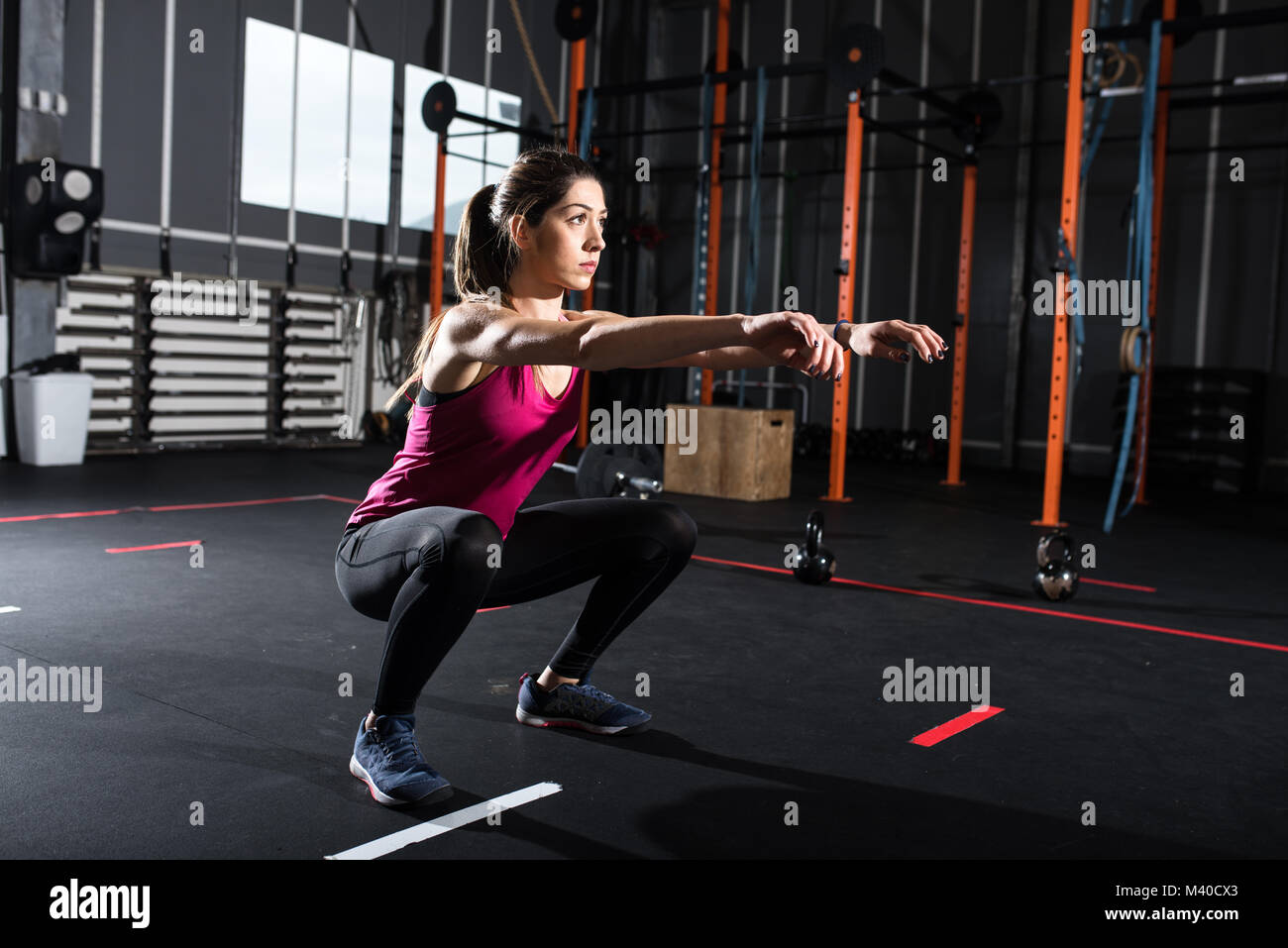 Athletic girl does squat exercises at the gym Stock Photo