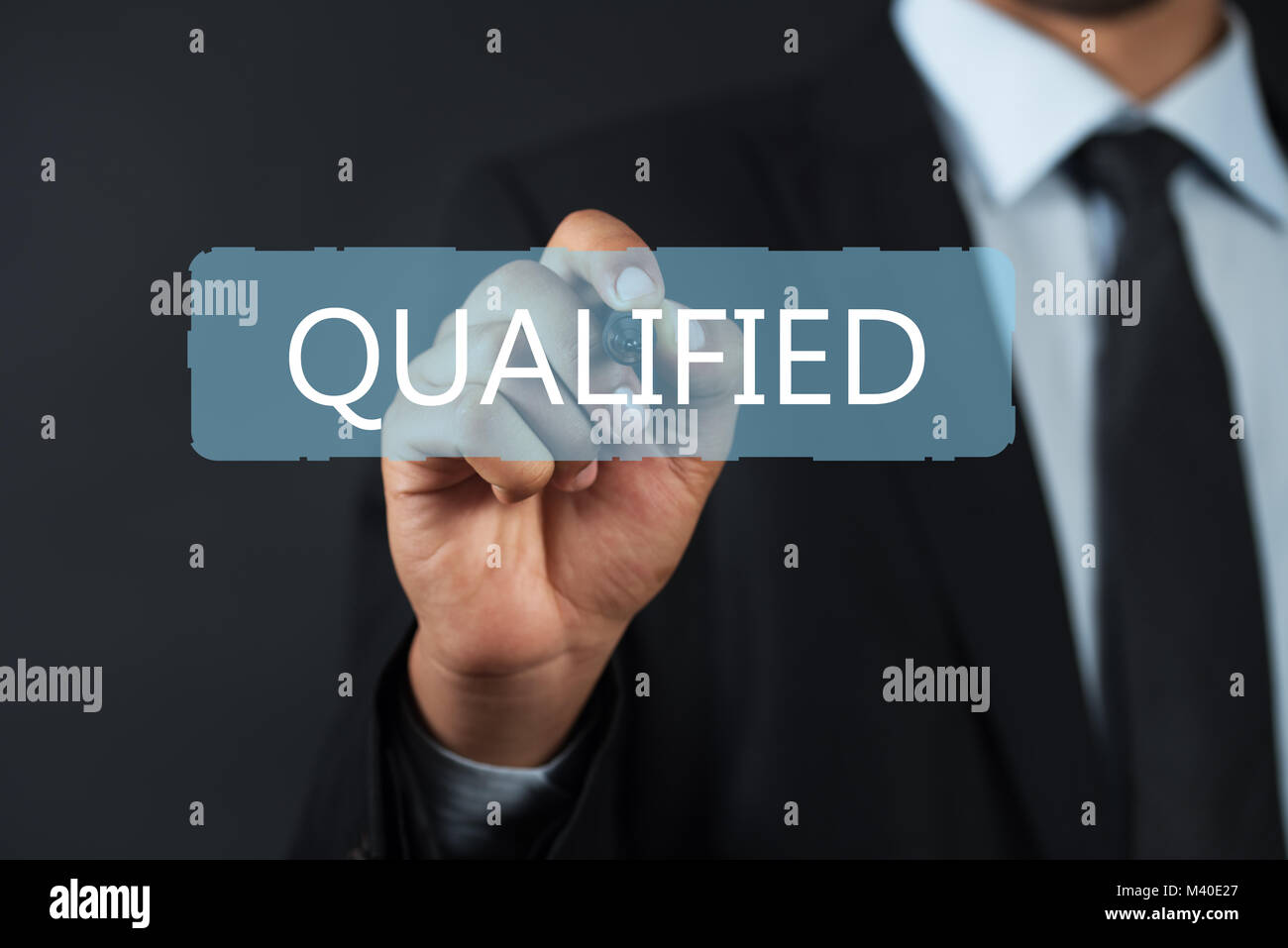Succesfuul Business man pointing the text: Qualified Stock Photo