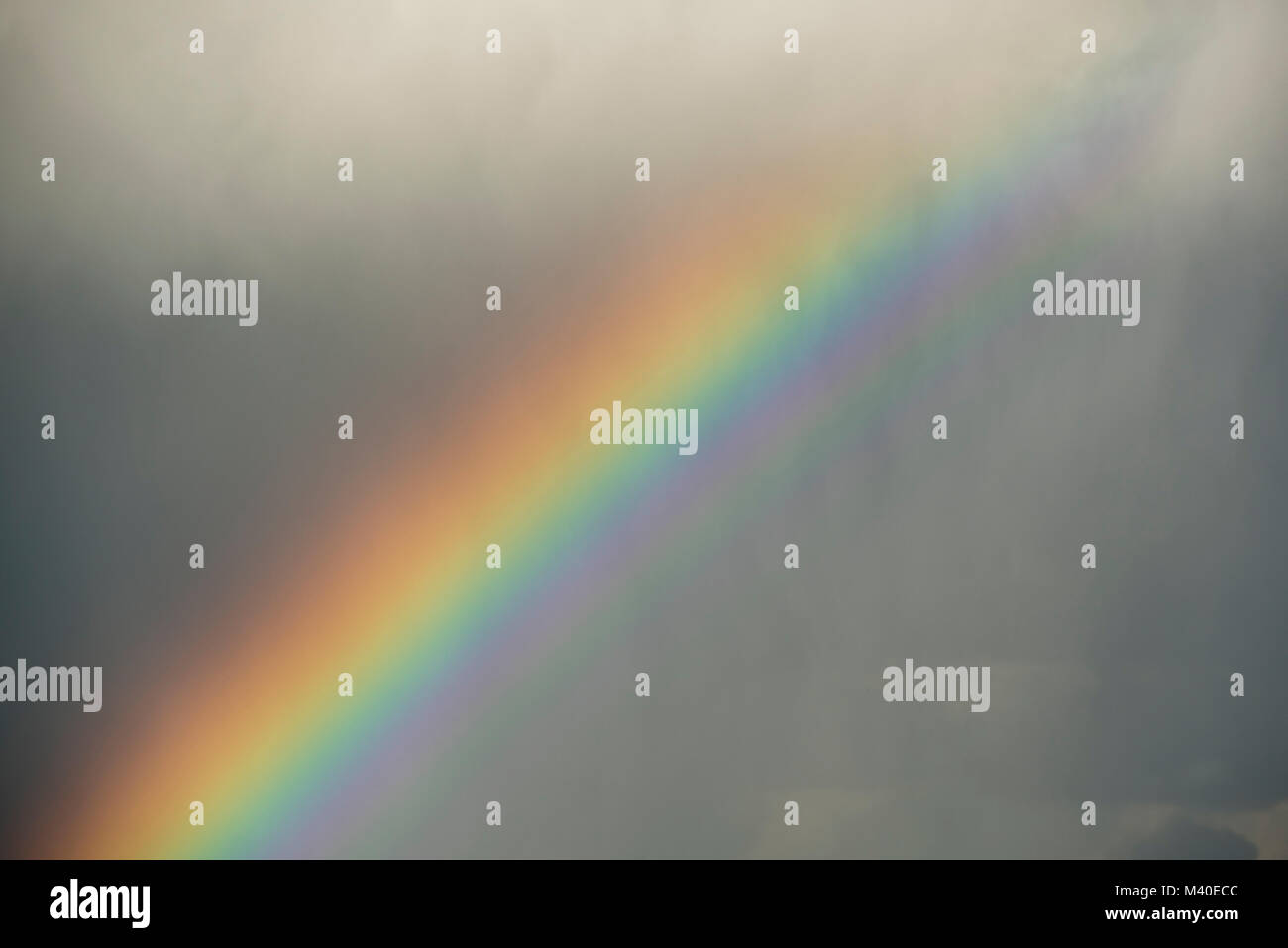 Portion of a rainbow below rain clouds in the spring Stock Photo - Alamy