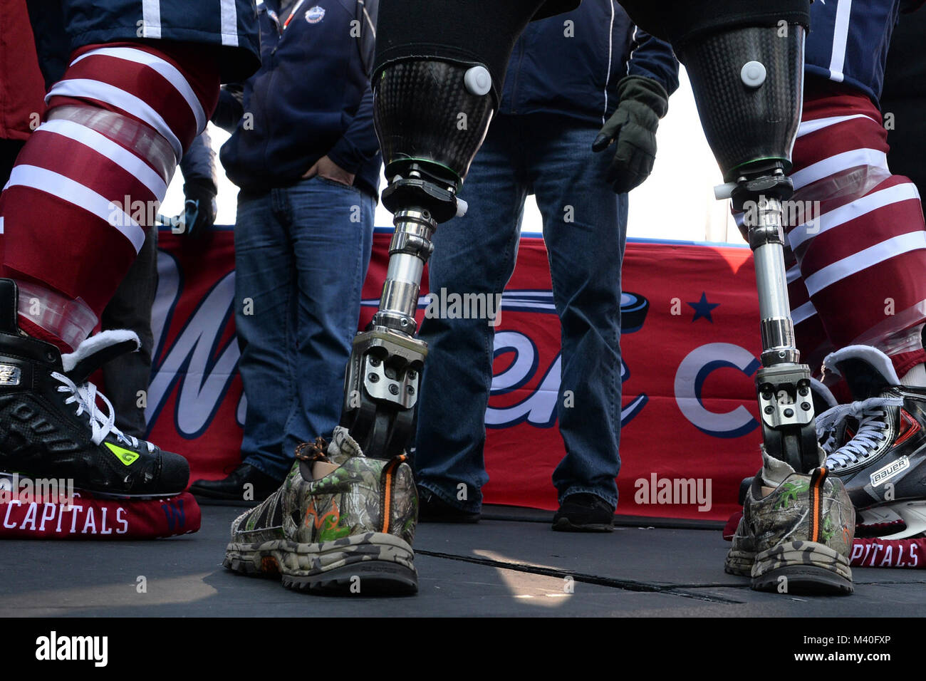 Hockey skates worn by Washington Capitals pro hockey players flank the artificial legs of Michael Cain of the USA Warriors sled hockey team during a media day for the Winter Classic 2015 at Nationals Park in Washington, D.C. Dec. 31, 2014.  The National Hockey League included the wounded veterans hockey club in media day, which included many media interviews, alongside the Chicago Blackhawks and Washington Capitals. (DoD News photo by EJ Hersom) 141231-D-DB155-001 by DoD News Photos Stock Photo