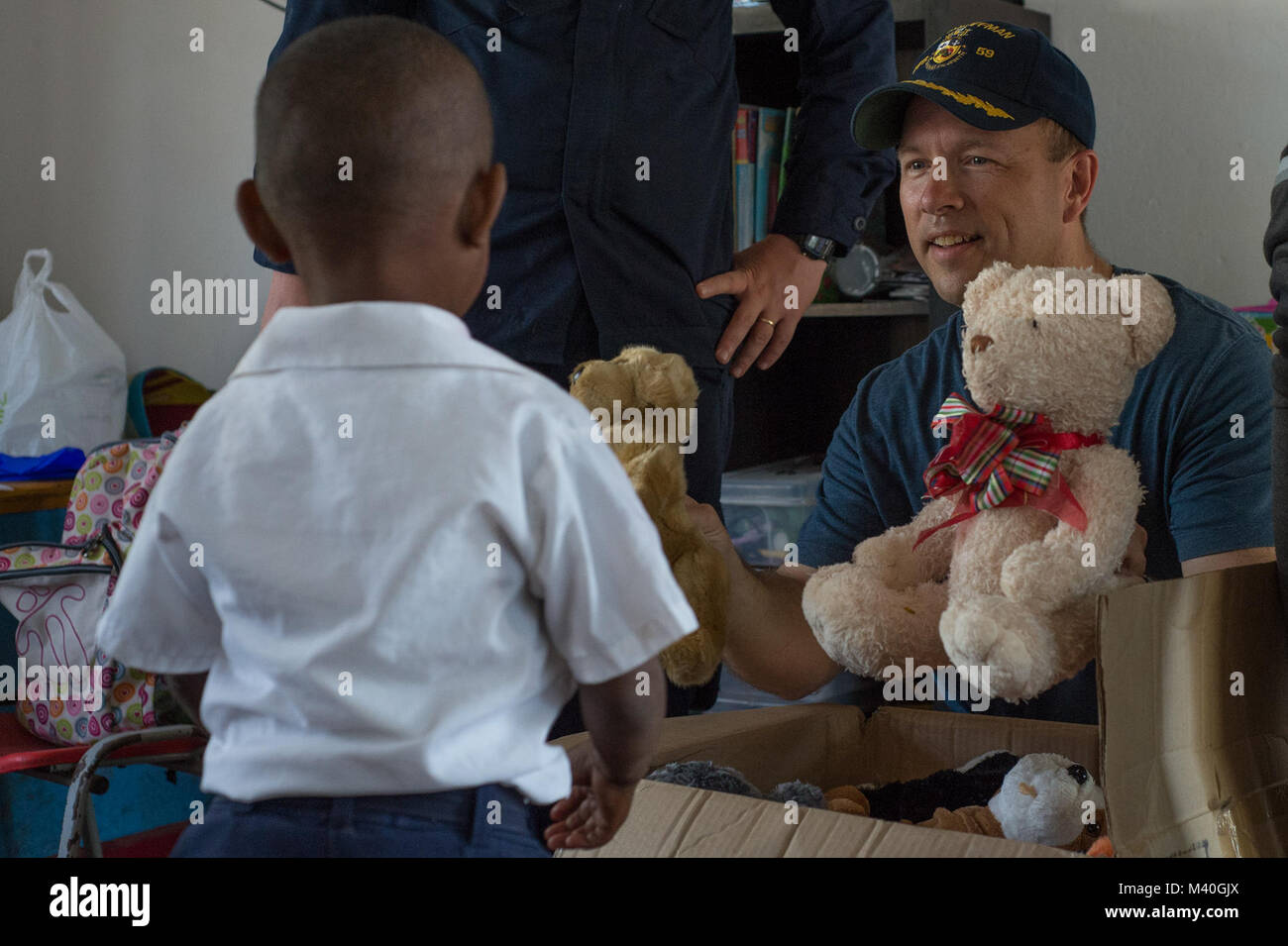 150216-N-IG780-168 CARTAGENA, Colombia (Feb. 16, 2015) Cdr. Michael Concannon, commanding officer of the guided-missile frigate USS Kauffman (FFG 59), gives a child a stuffed animal during a community service project. Kauffman is underway in support of Operation Martillo, a joint operation with the U.S. Coast Guard and partner nations within the 4th Fleet area of responsibility. (U.S. Navy photo by Mass Communication Specialist 3rd Class Shane A. Jackson/Released) 150216-N-IG780-168 by ussouthcom Stock Photo