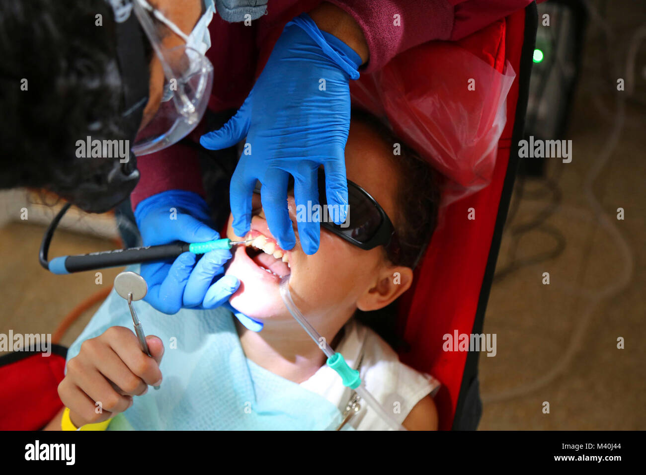 150423-A-ZA034-095 PUERTO BARRIOS, Guatemala (April 23, 2015) Janae Smart, a registered dental hygienist assigned to Naval Air Station Oceana, Virginia Beach, Va., performs a teeth cleaning at a medical site set up at Casa Social Del Maestro Prof. Leopoldo during Continuing Promise 2015.  2015. Continuing Promise is a U.S. Southern Command-sponsored and U.S. Naval Forces Southern Command/U.S. 4th Fleet-conducted deployment to conduct civil-military operations including humanitarian-civil assistance, subject matter expert exchanges, medical, dental, veterinary and engineering support and disast Stock Photo