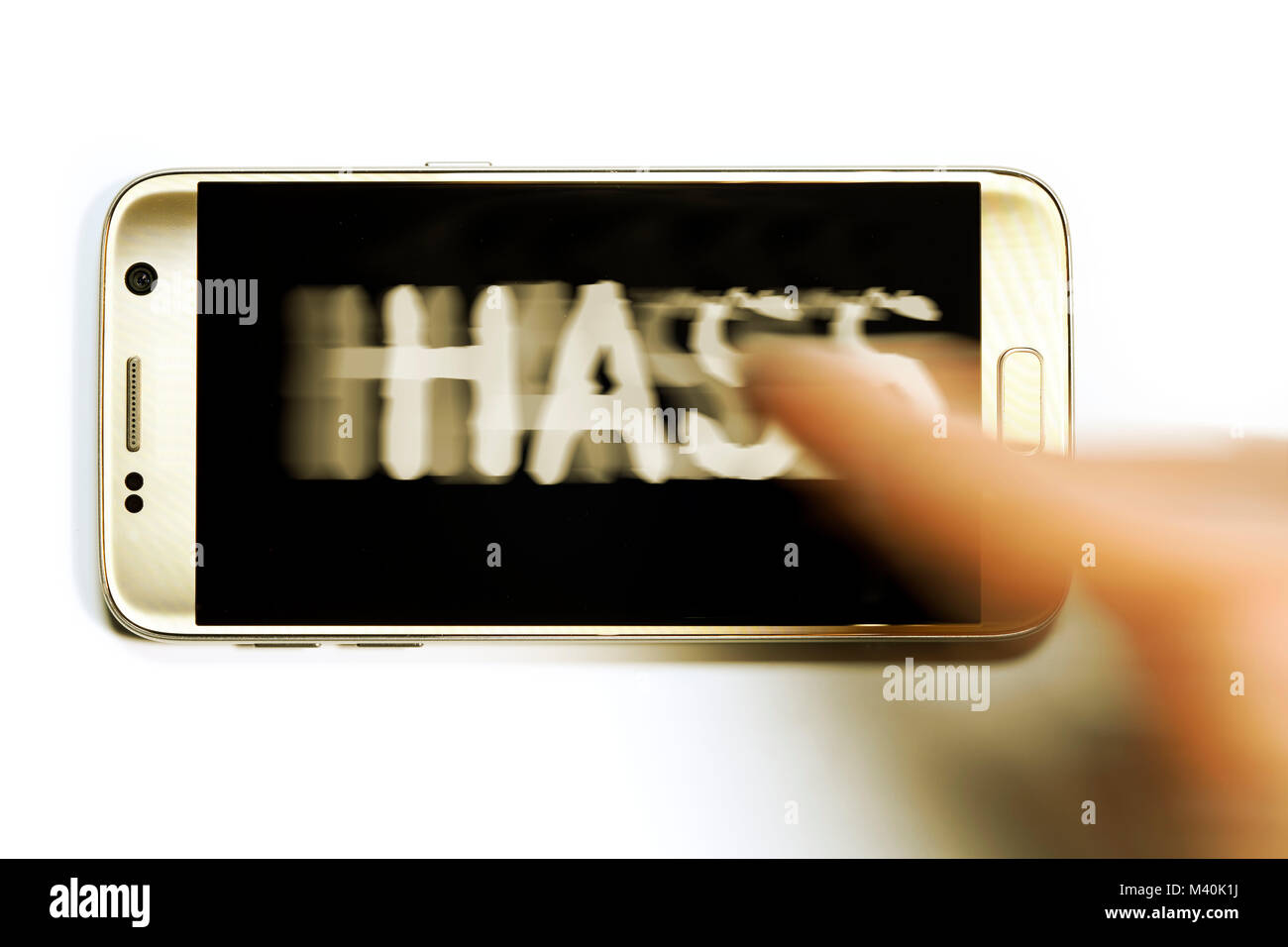 The word hatred swept by the mobile phone display, Das Wort Hass wird vom Handydisplay gewischt Stock Photo
