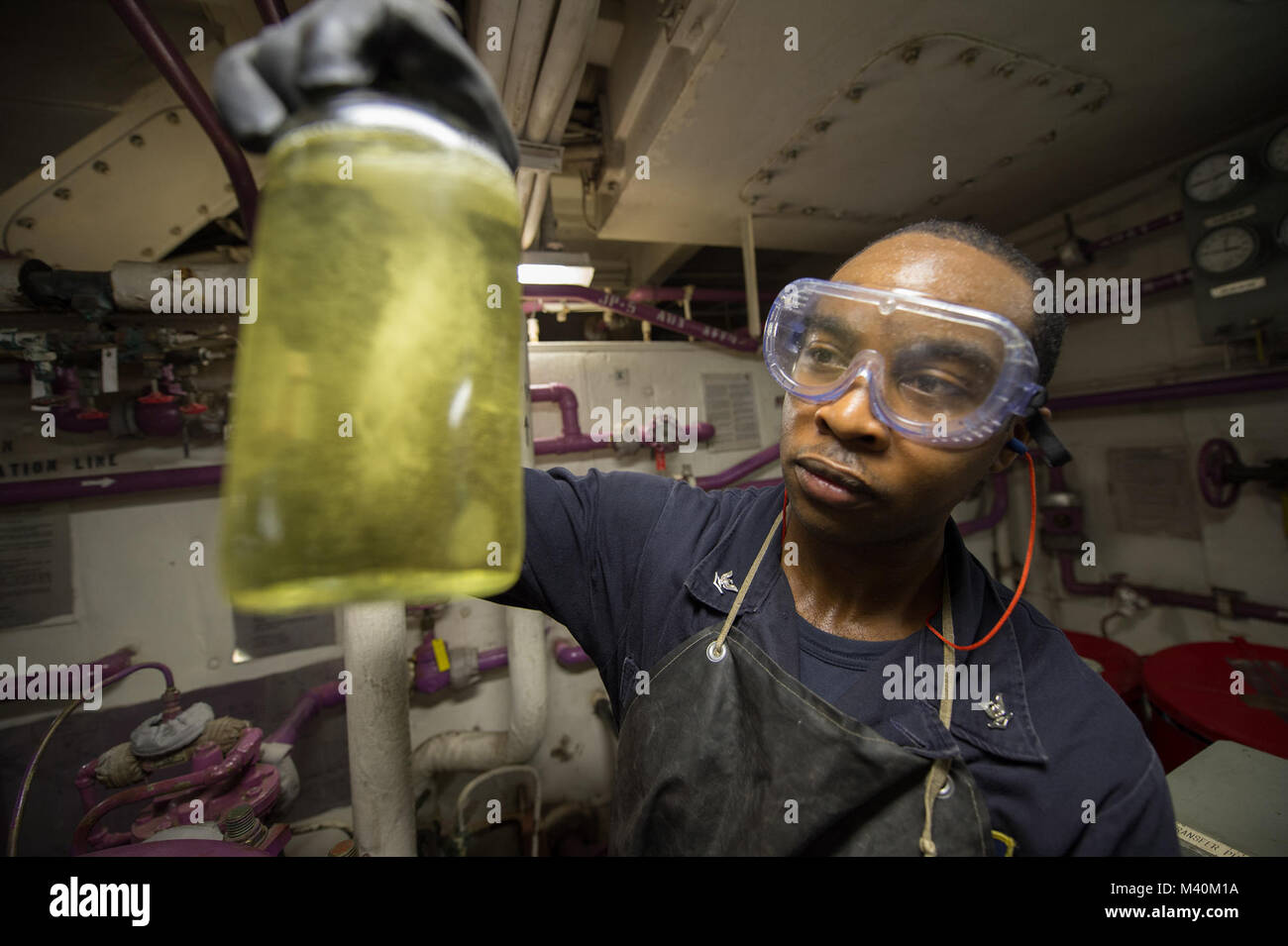 150521-N-IG780-018 PACIFIC OCEAN (May 21, 2015) — Gas Turbine System Technician (Mechanical) 3rd Class Terrence Brooks inspects a jar of JP-5 fuel for impurities prior to refueling an SH-60B 'Seahawk' helicopter on board guided-missile frigate USS Kauffman (FFG 59). Kauffman is currently underway in support of Operation Martillo, a joint operation with the U.S. Coast Guard and partner nations within the 4th Fleet area of responsibility. (U.S. Navy photo by Mass Communication Specialist 3rd Class Shane A. Jackson/Released) 150521-N-IG780-018 by U.S. Naval Forces Southern Command  U.S. 4th Fleet Stock Photo