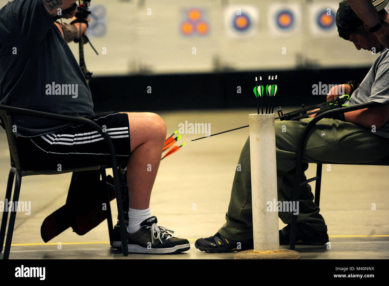 Capt. Anthony Simone (right) prepares his bow before shooting a set of ...