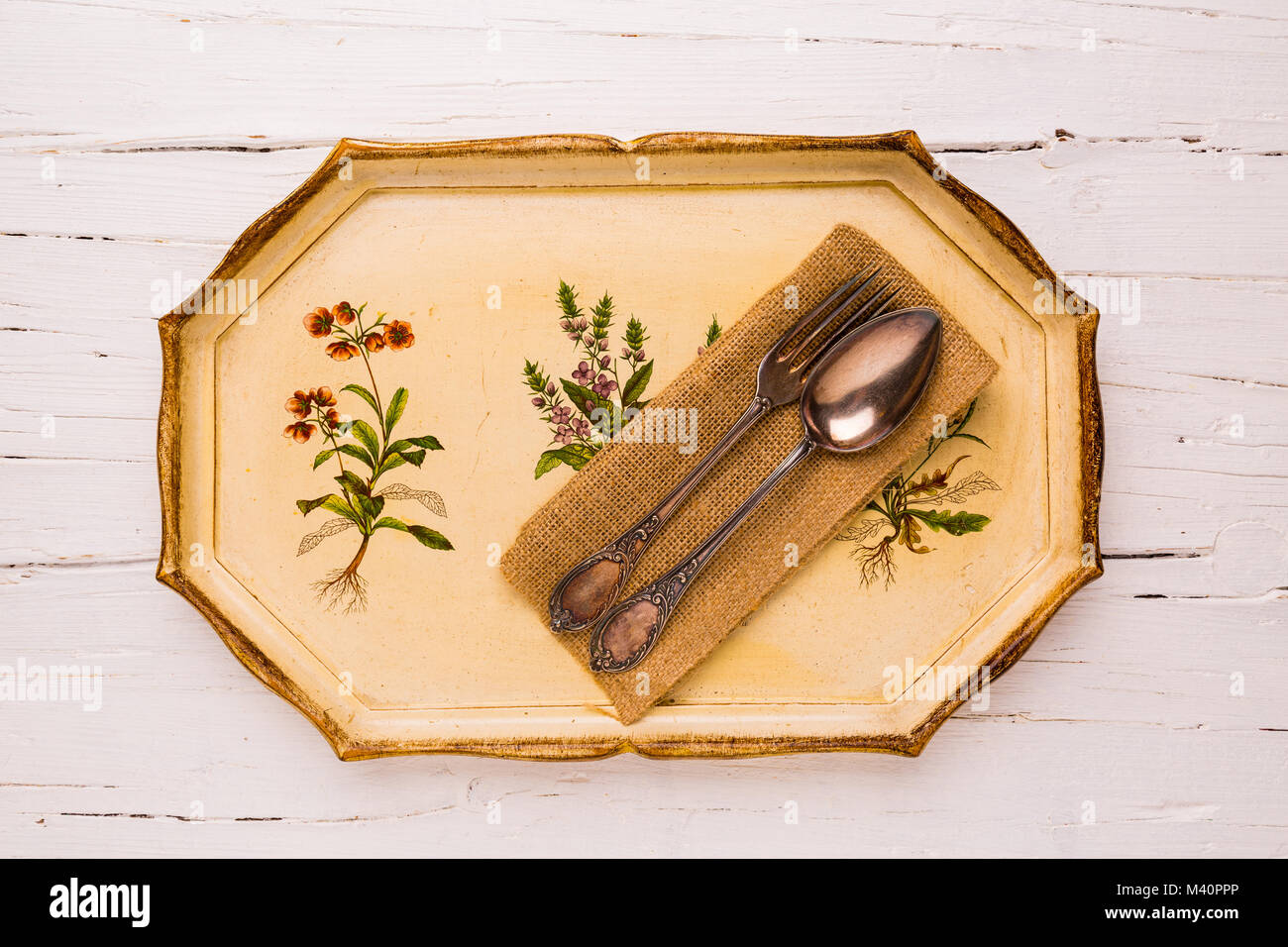 Antique tray with old cutlery spoon and fork  on white wooden background, view from above, flatlay. Stock Photo