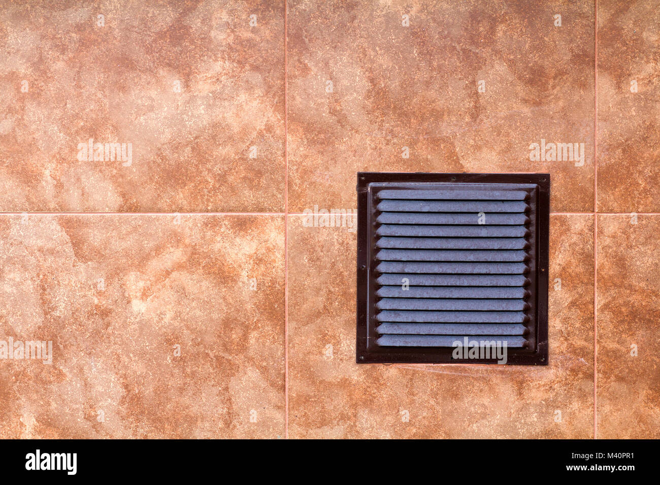 Brown metal industrial panel with ventilation grilles, closeup photo, front view. Detail of