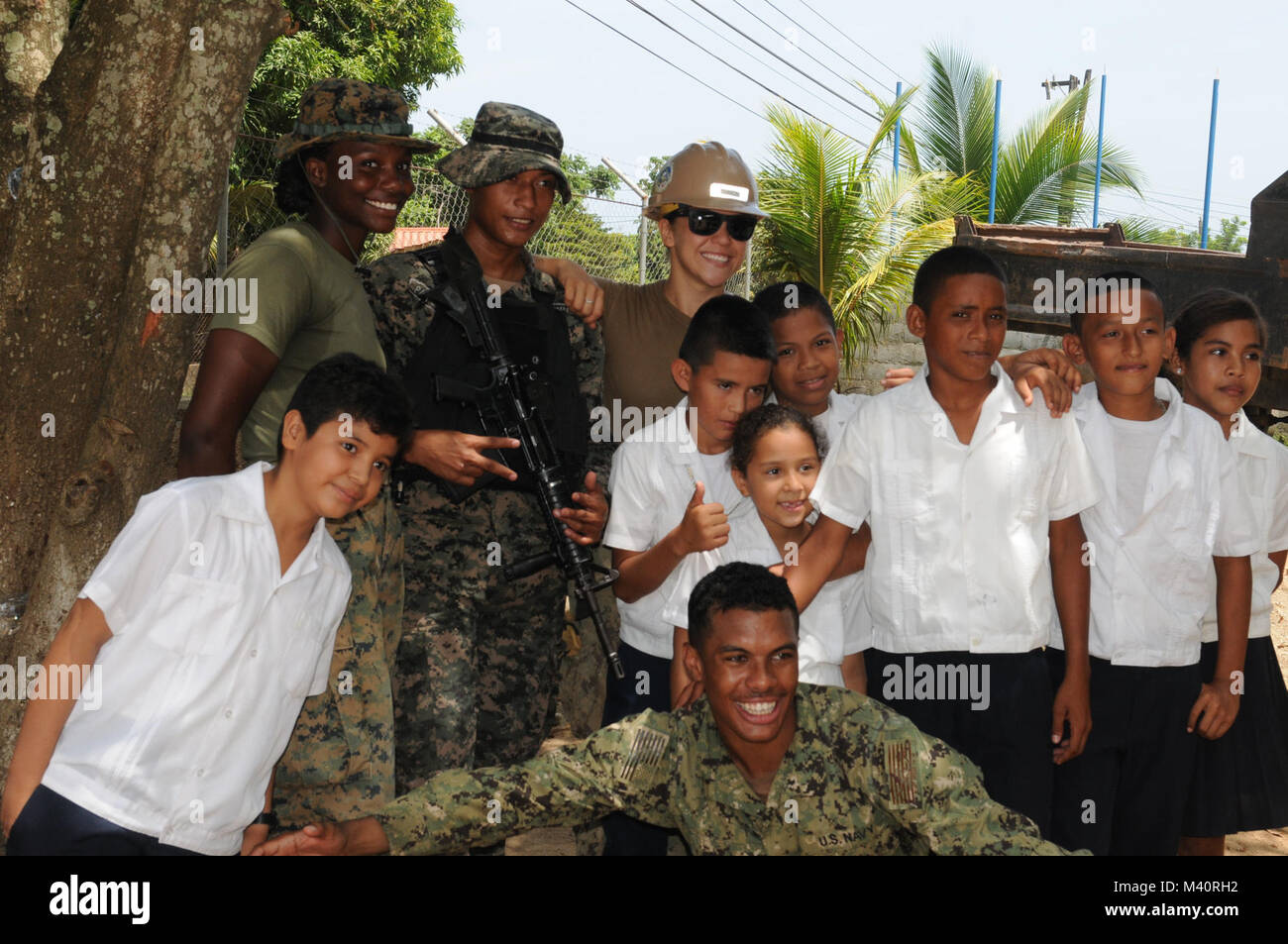 Marines and Sailors take a break from their work to take a picture with Honduran children from the Escuela Vilma Yolanda Castillo in Trujillo, Honduras. The Joint-service personnel are deployed as part of the Adaptive Force Package in support of Southern Partnership Station-Joint High Speed Vessel 2015 (SPS-JHSV 15).  SPS-JHSV 15 is an annual series of U.S. Navy deployments, fostering a lasting relationship with the host nations by promoting and enhancing regional stability and security through the sharing of experiences. (U.S. Army photo by Sgt. Flor Gonzalez/Released) 150720-A-FC375-175 by U Stock Photo