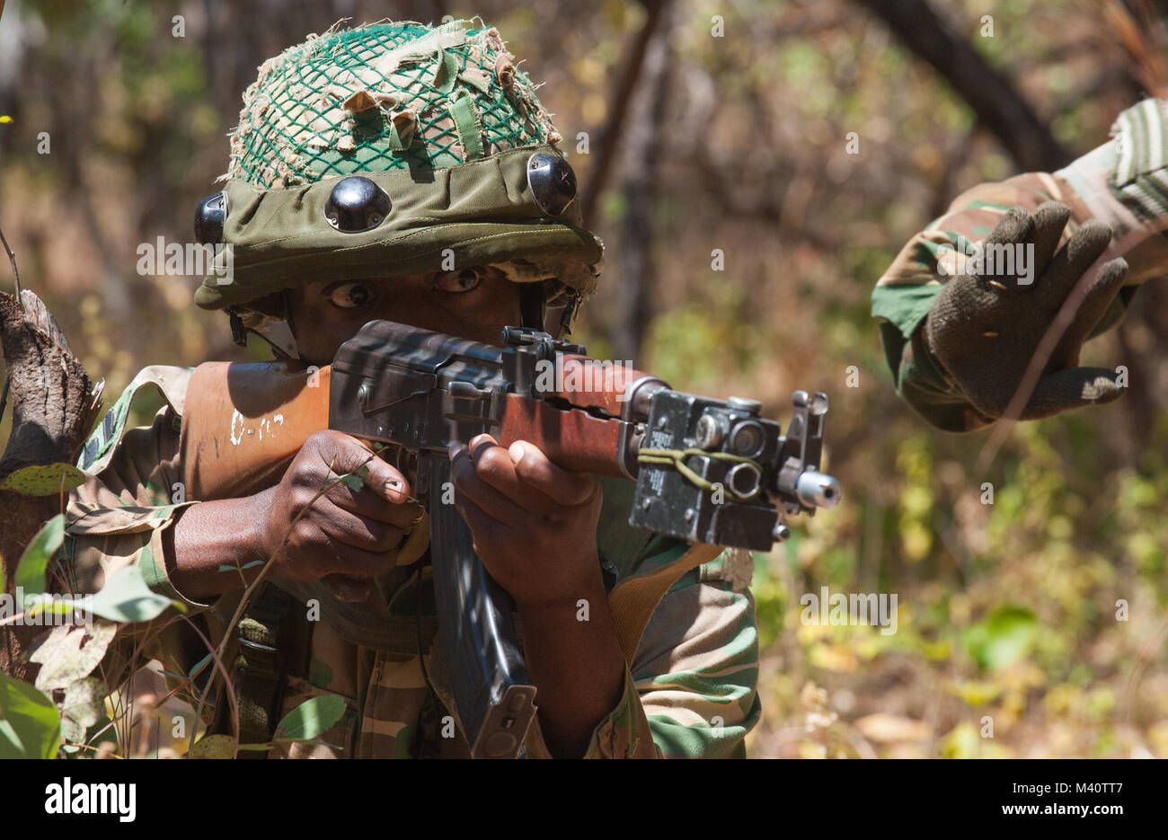 A member of the Zambian Defense Force draws his weapons during a