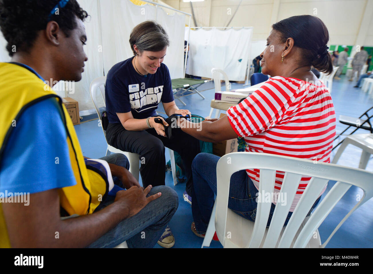 150816-N-AT101-385 SANTO DOMINGO, Dominican Republic (Aug. 16, 2015) A volunteer occupational therapist with the non-governmental organization (NGO) Project HOPE treats a patient at a medical site established at Parque del Este during Continuing Promise 2015 (CP-15). Project HOPE volunteers are working alongside other NGOs and military members during CP-15. Continuing Promise is a U.S. Southern Command-sponsored and U.S. Naval Forces Southern Command/U.S. 4th Fleet-conducted deployment to conduct civil-military operations including humanitarian-civil assistance, subject matter expert exchanges Stock Photo