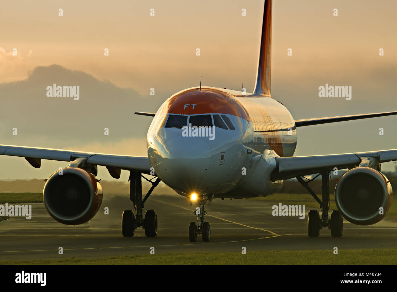 An Easyjet passenger plane taxiing out to the runway for take off at Liverpool John Lennon Airport at dusk. Stock Photo