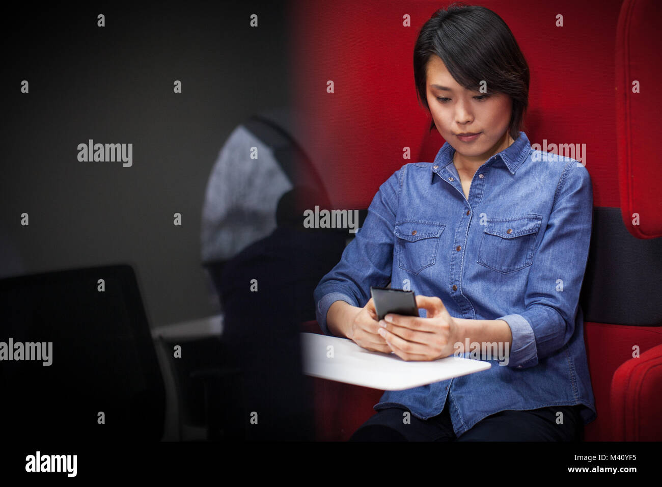 Businesswoman in a pod using smartphone Stock Photo