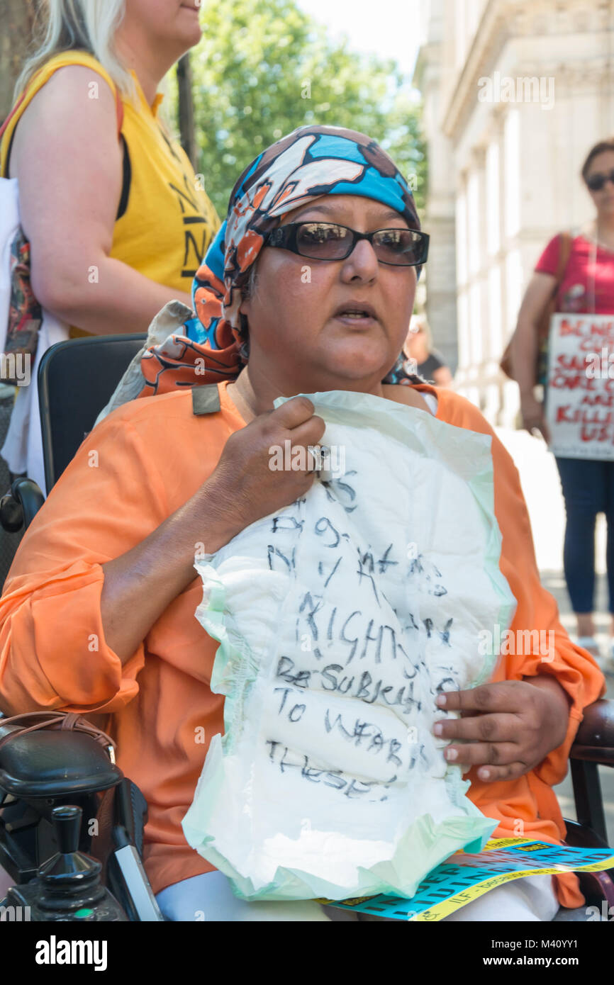 A wheelchair user holds up an incontinence pad with a message that
