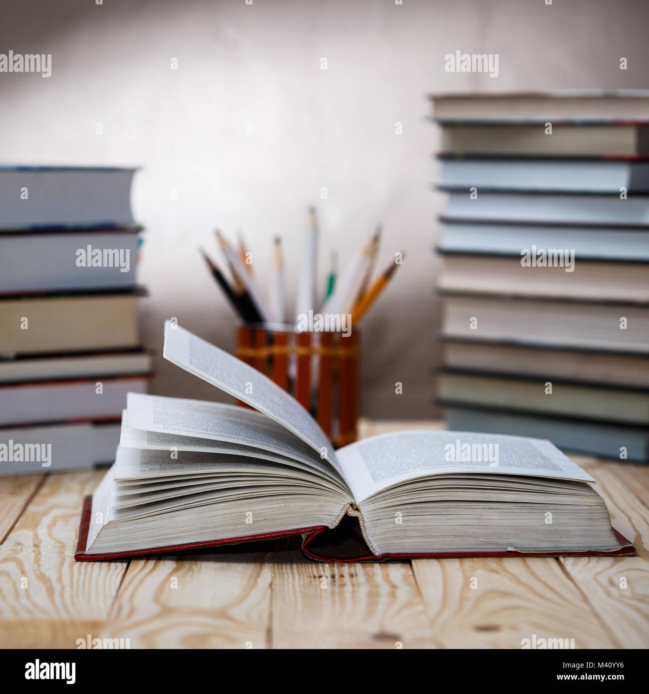 Open textbooks on wood desk with blurred focus for education background. Back to school concept Stock Photo