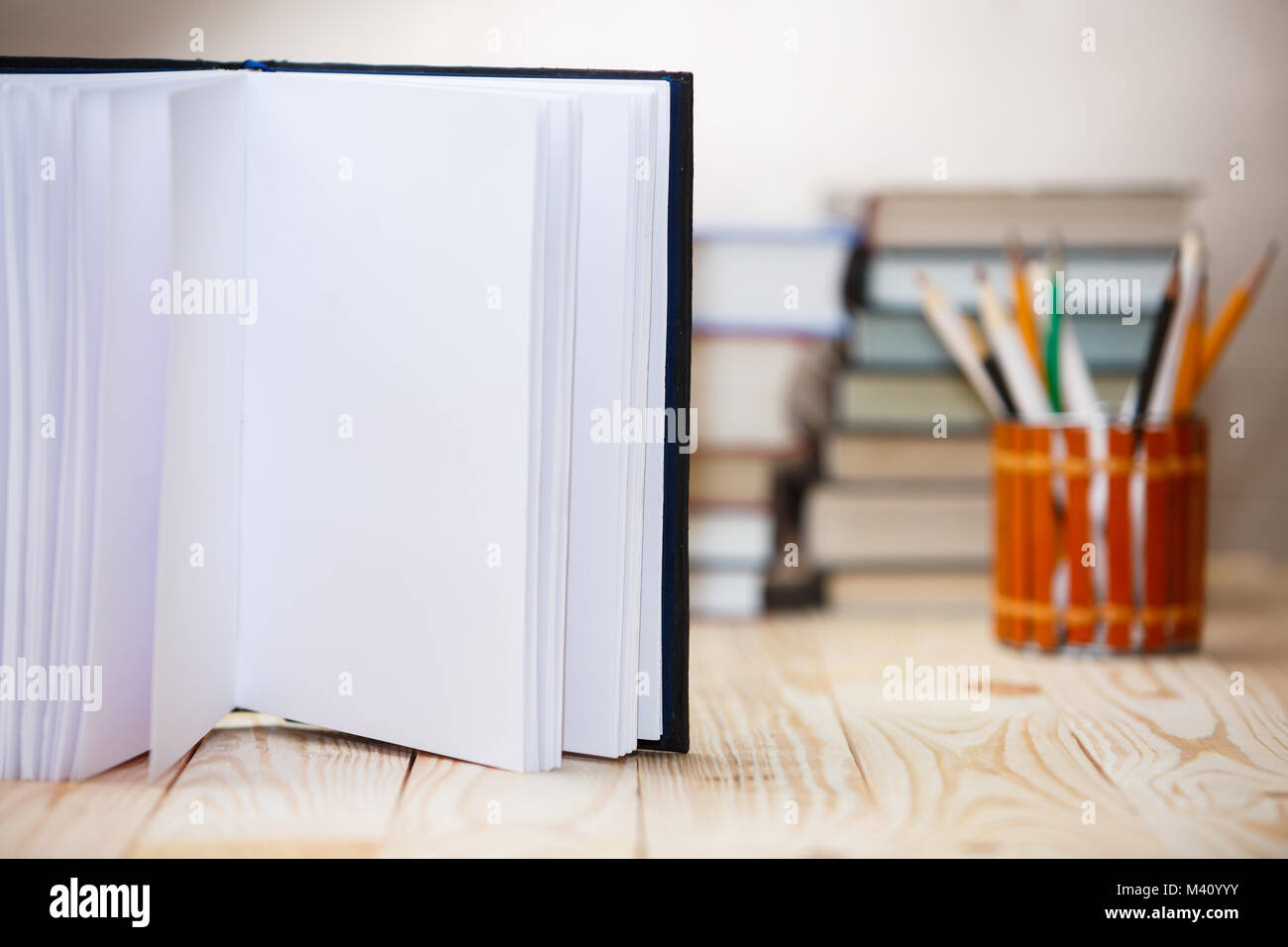 Open book on wood desk with blurred focus for background. Stock Photo