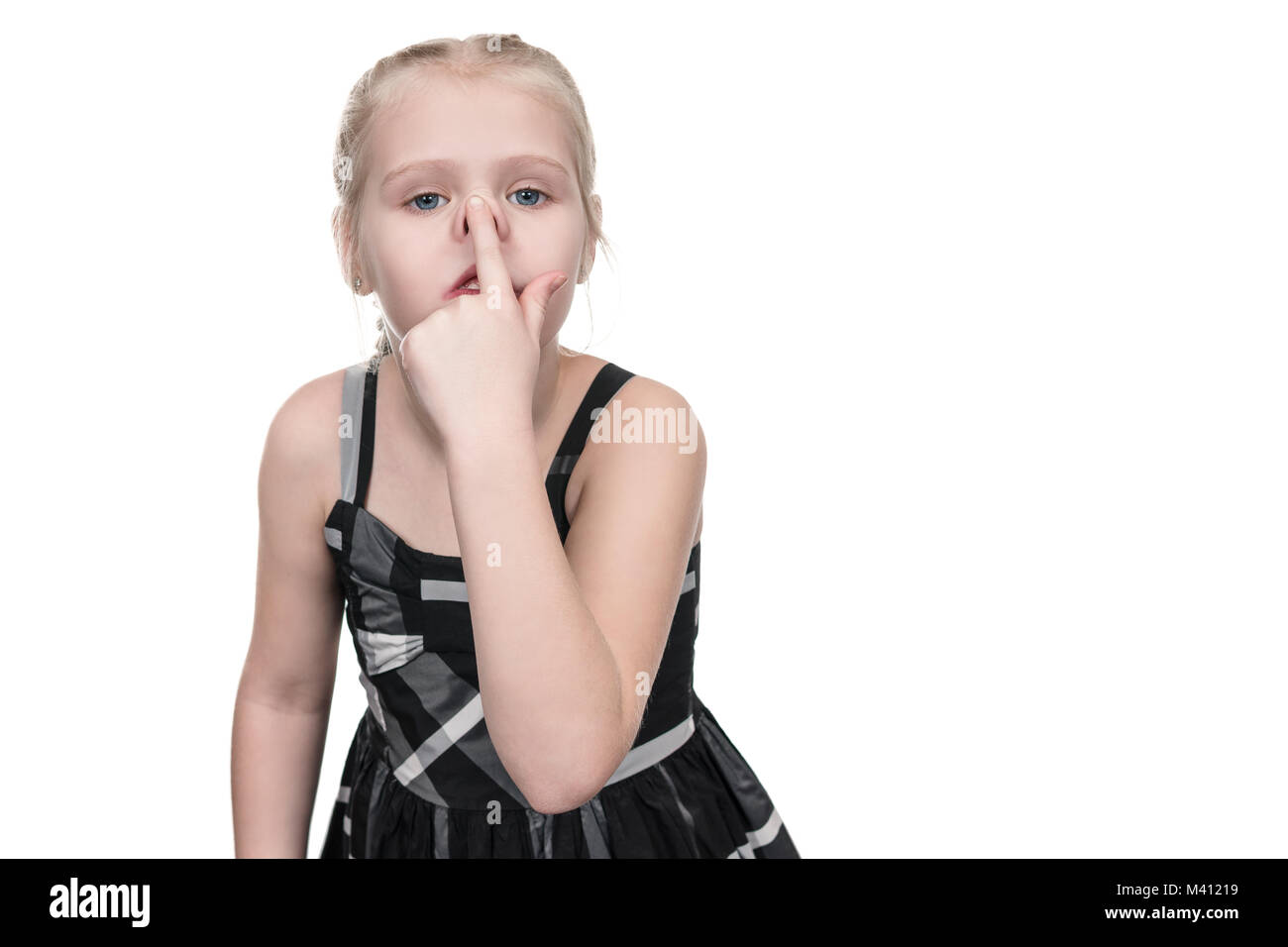 Little girl grimaces pushing on her nose isolated on white background