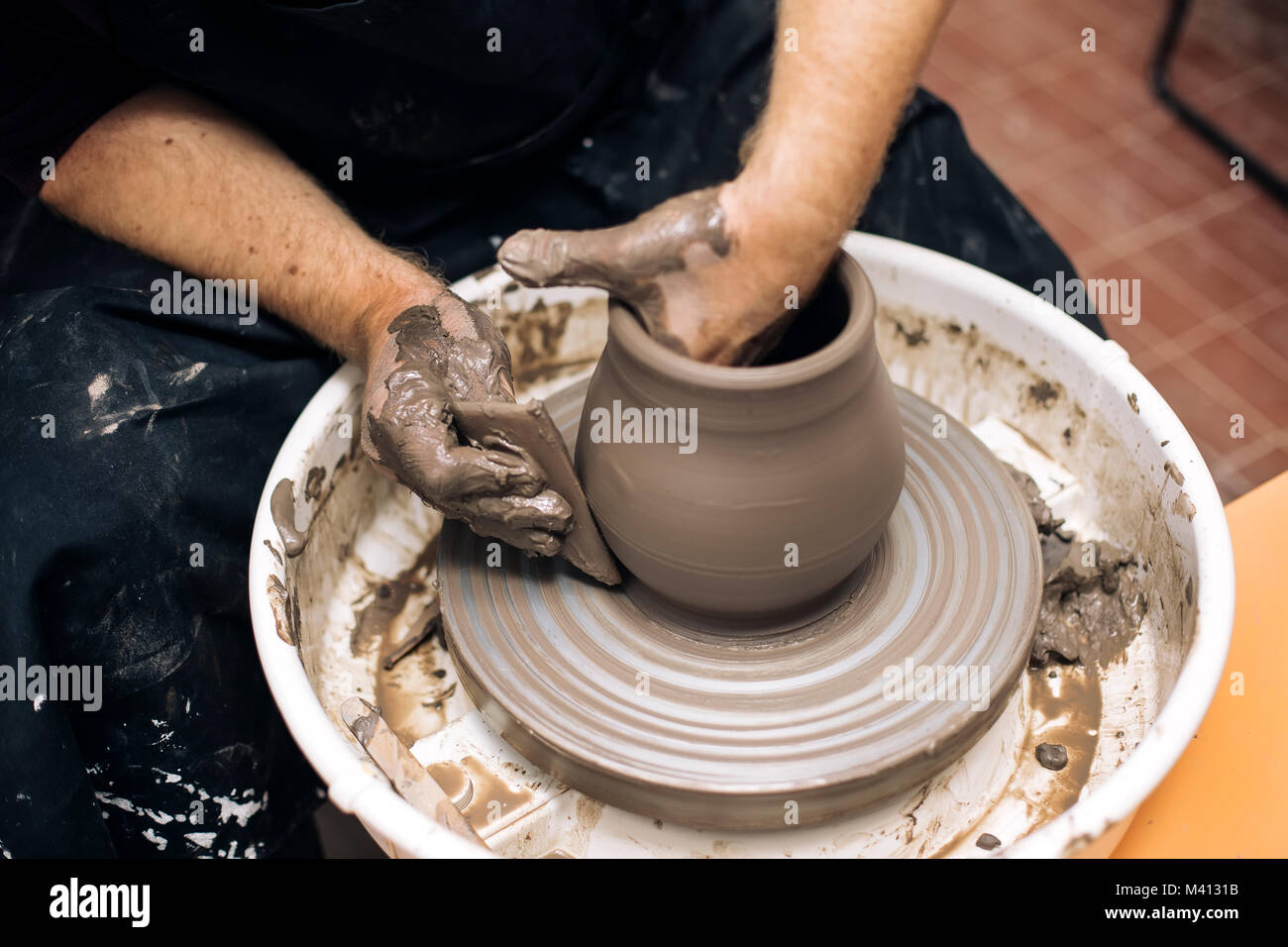 Close up detail view at an artist makes clay pottery on a spin wheel