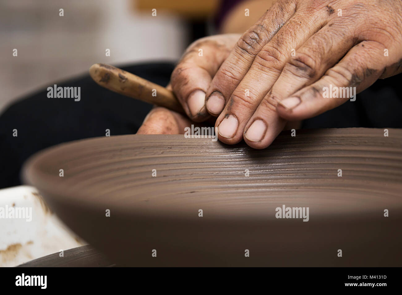 Close up detail view at an artist makes clay pottery on a spin wheel