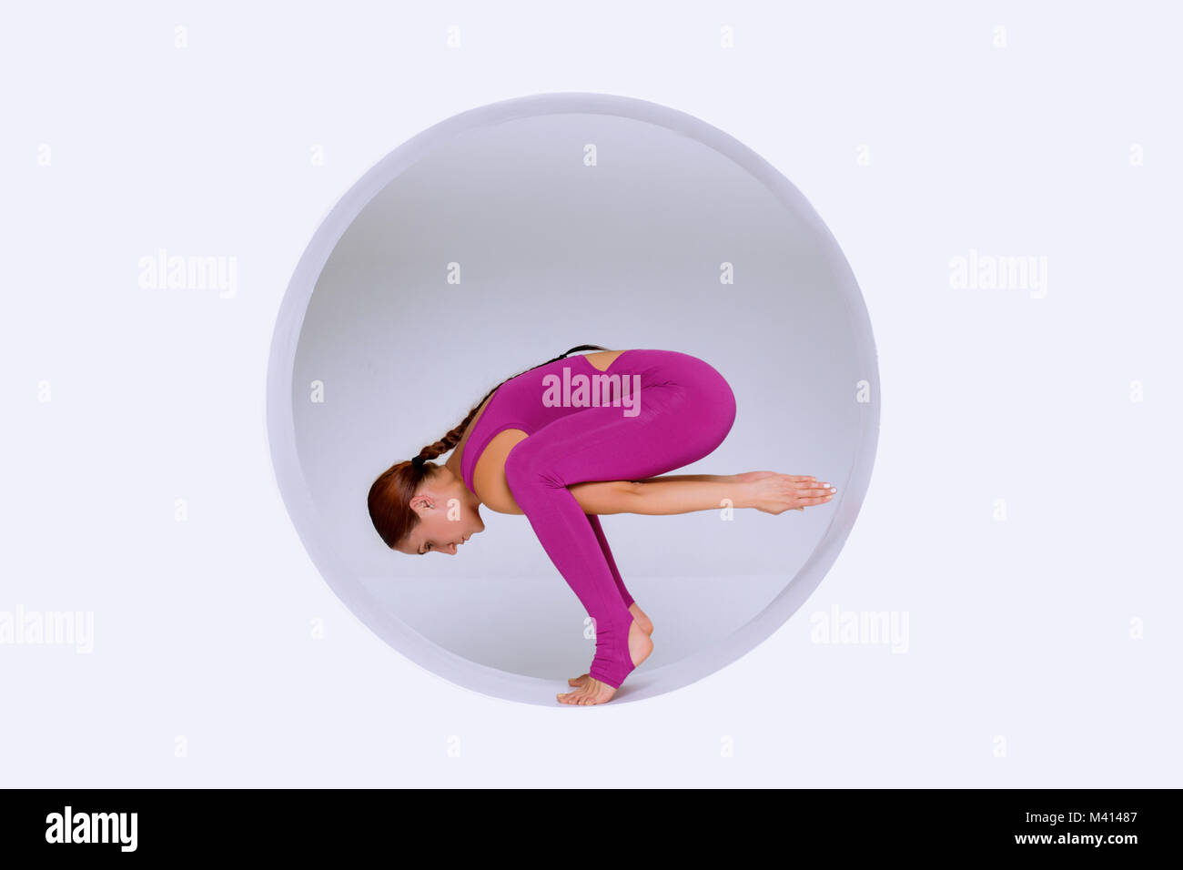 Beautiful and slim woman  active wear,   practicing  yoga exercises in geometric  design of round shapes,in sphere. Creative concept  sports  on white Stock Photo