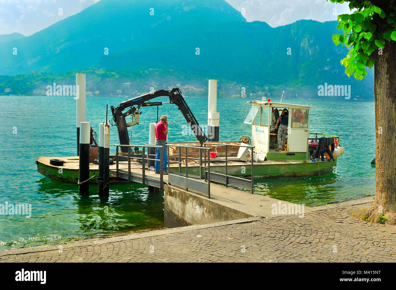 Freight carrying boat loaded with building materials berthed on Lake Como, Italy Stock Photo