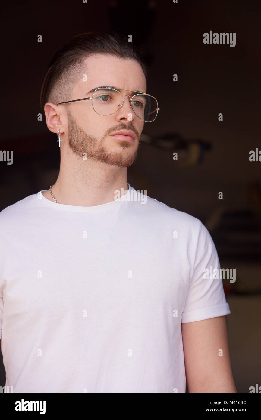 Head and shoulders of a Young man with a beard wearing a white tshirt