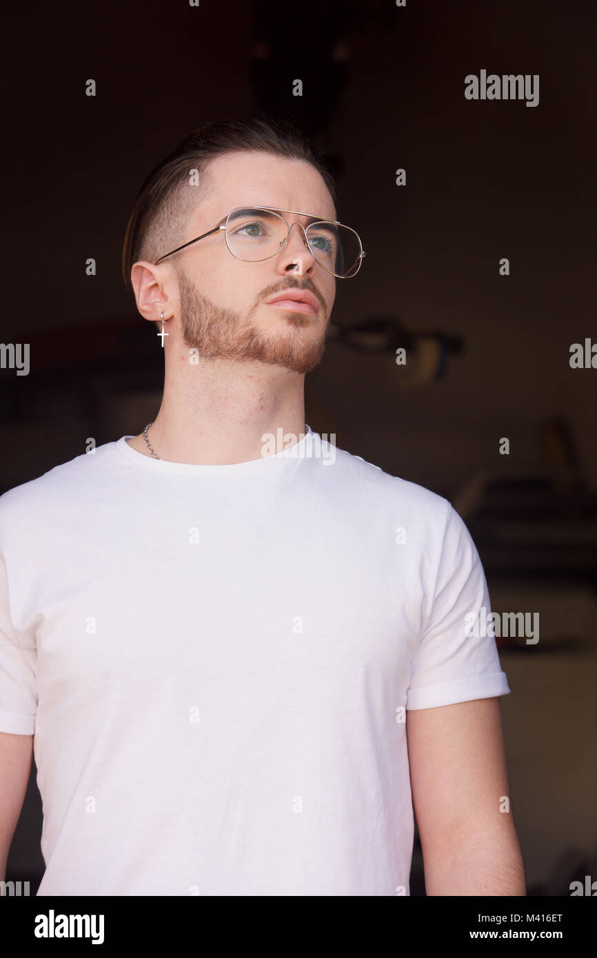 Head and shoulders of a Young man with a beard wearing a white tshirt