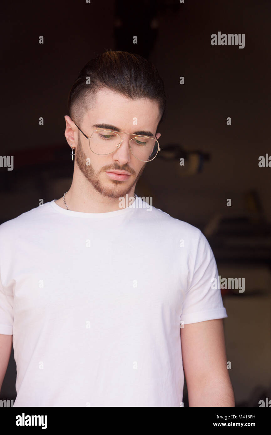 Head and shoulders of a Young man with a beard wearing a white tshirt