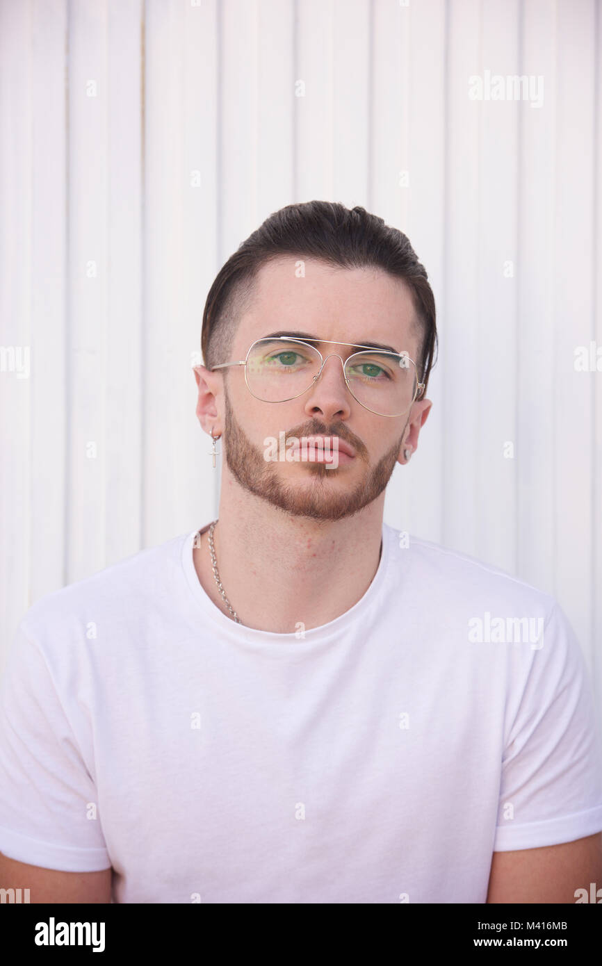 Head and shoulders of a Young man with a beard wearing a white tshirt