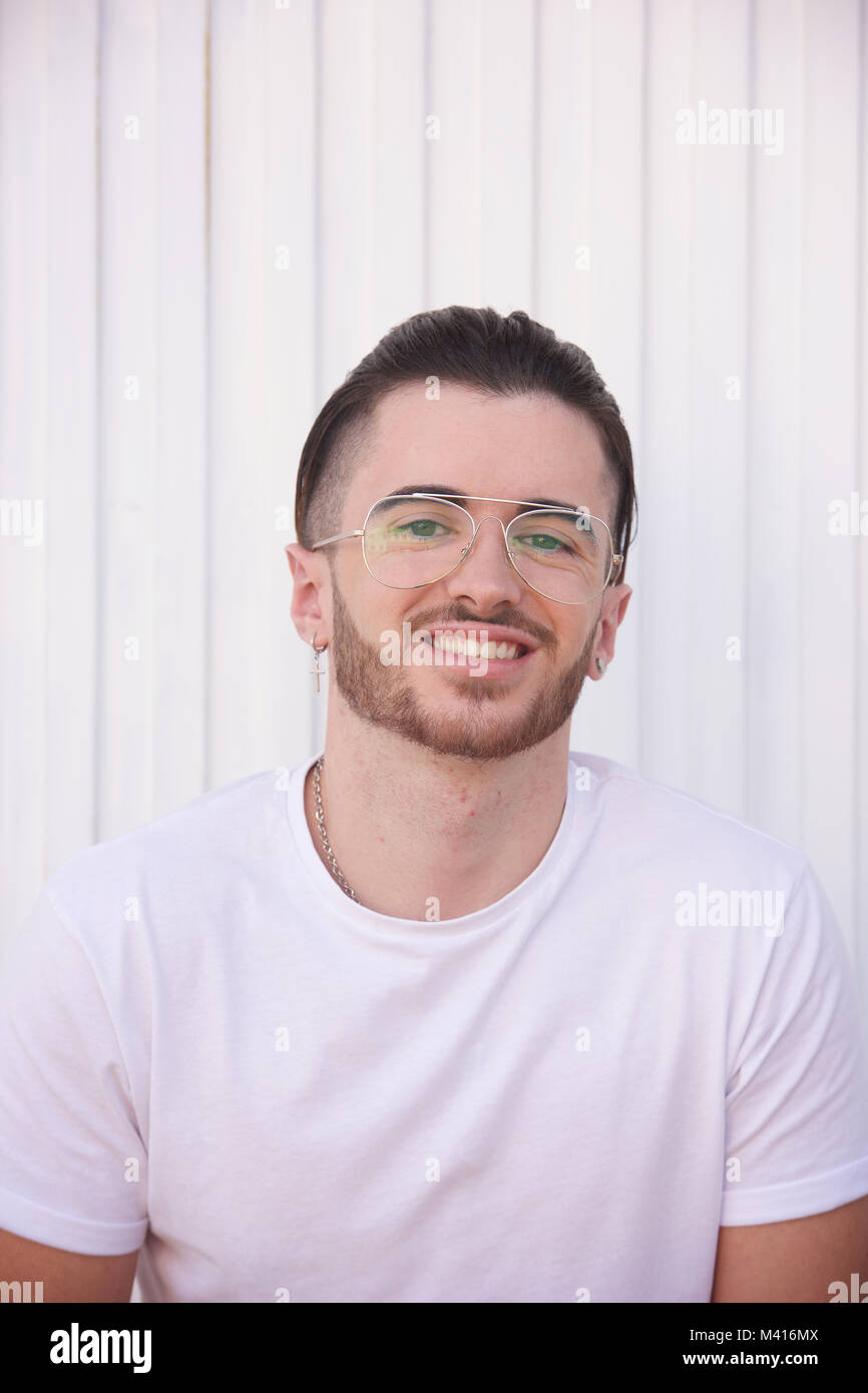 Head and shoulders of a Young man with a beard wearing a white tshirt