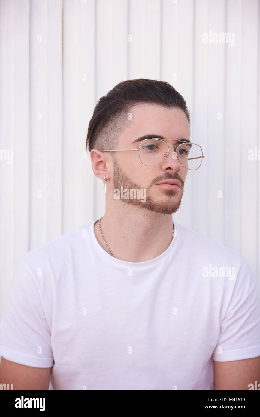 Head and shoulders of a Young man with a beard wearing a white tshirt