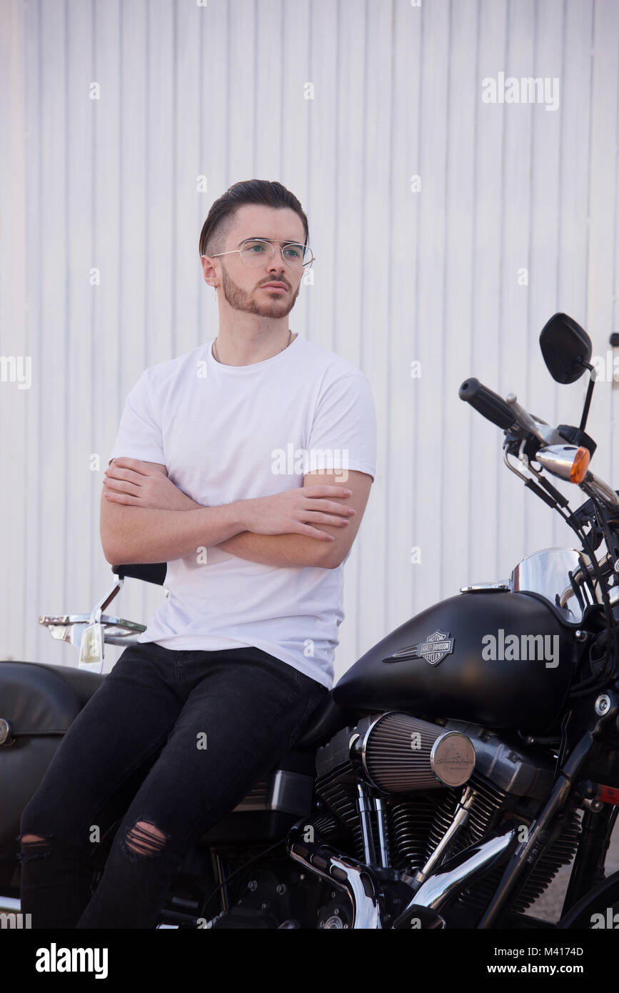 Young man with a beard wearing a white tshirt and a Harley Davidson