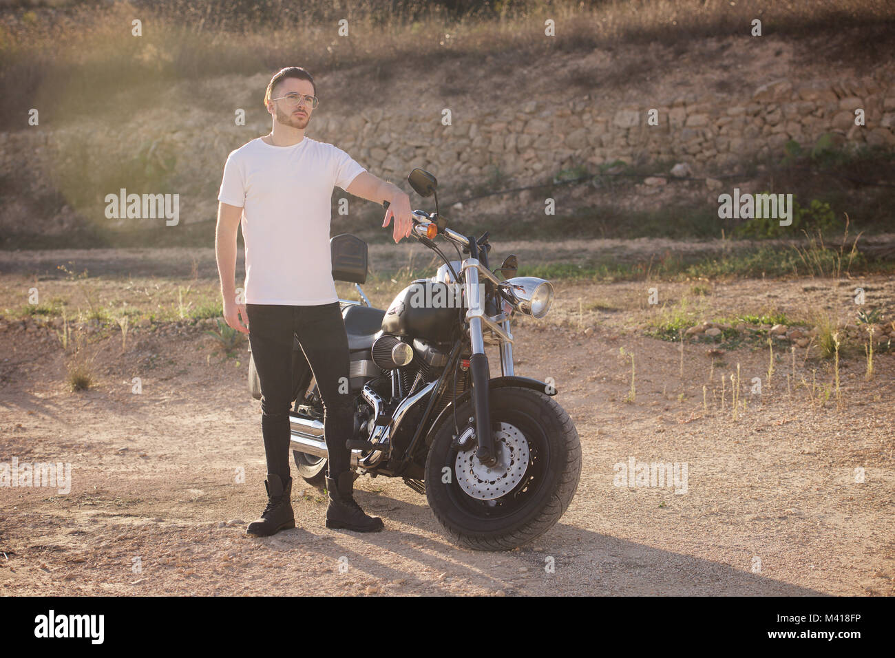 Young man with a beard wearing a white tshirt and a Harley Davidson