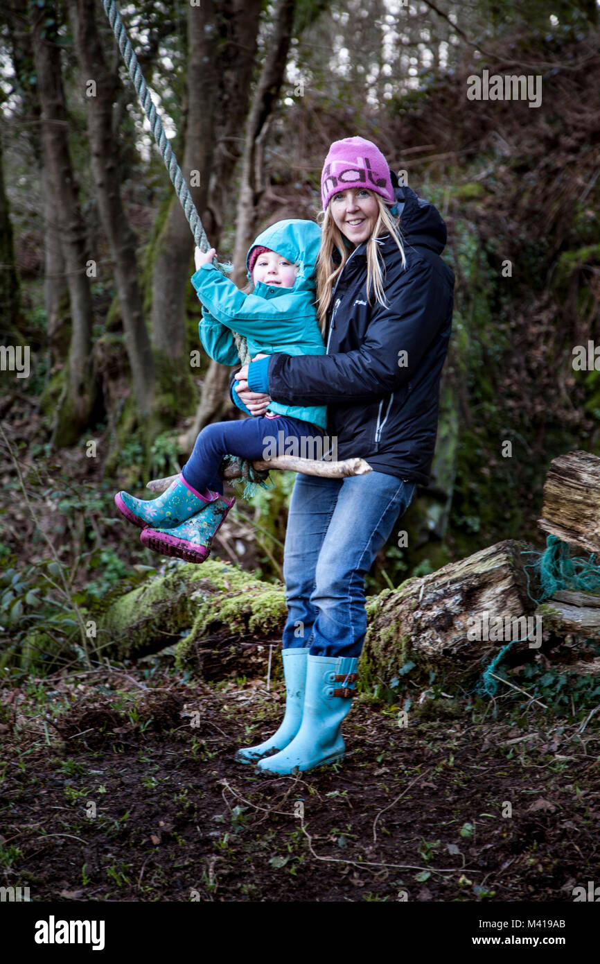 Mother and child playing on an outdoor rope swing Stock Photo