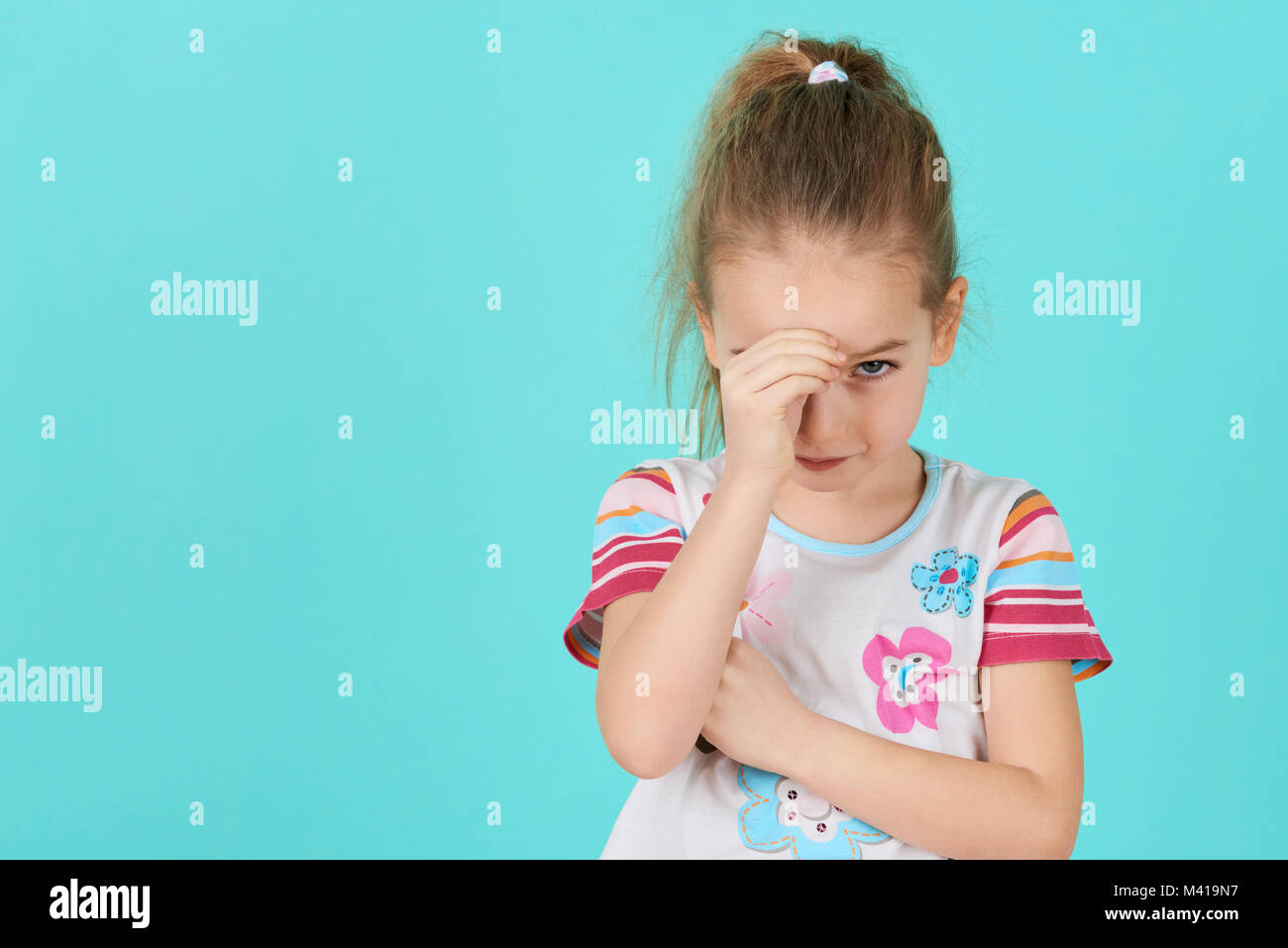 Upset problem child with head in hands. Bullying, depression, stress or frustration concept. Angry little girl background with copy space. Stock Photo