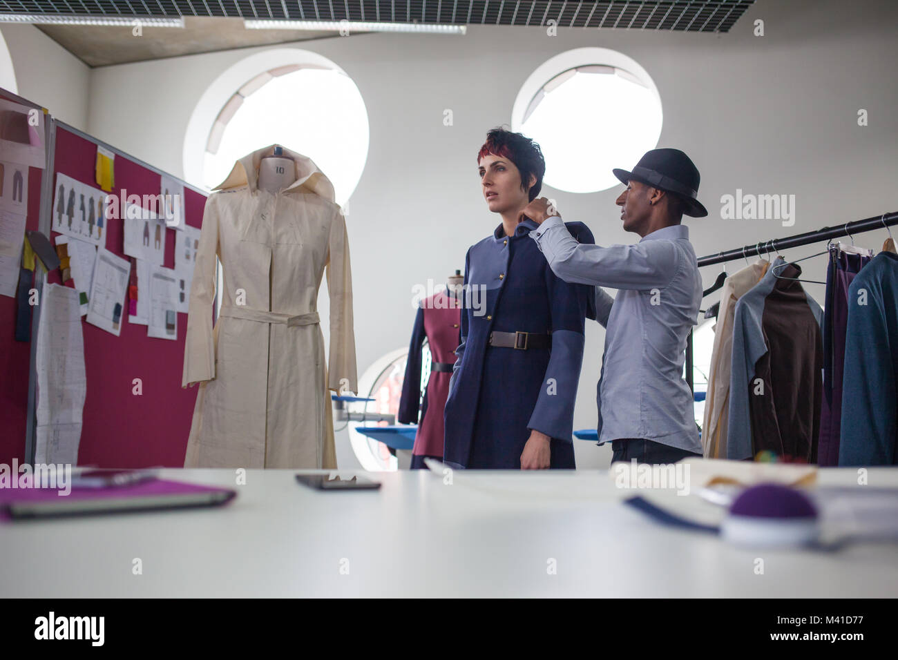 Fashion designer pinning garment on a model Stock Photo