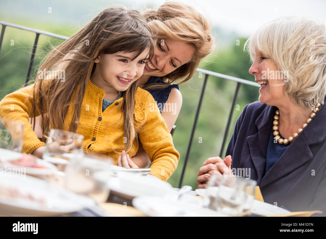Three generations of women at a family meal Stock Photo