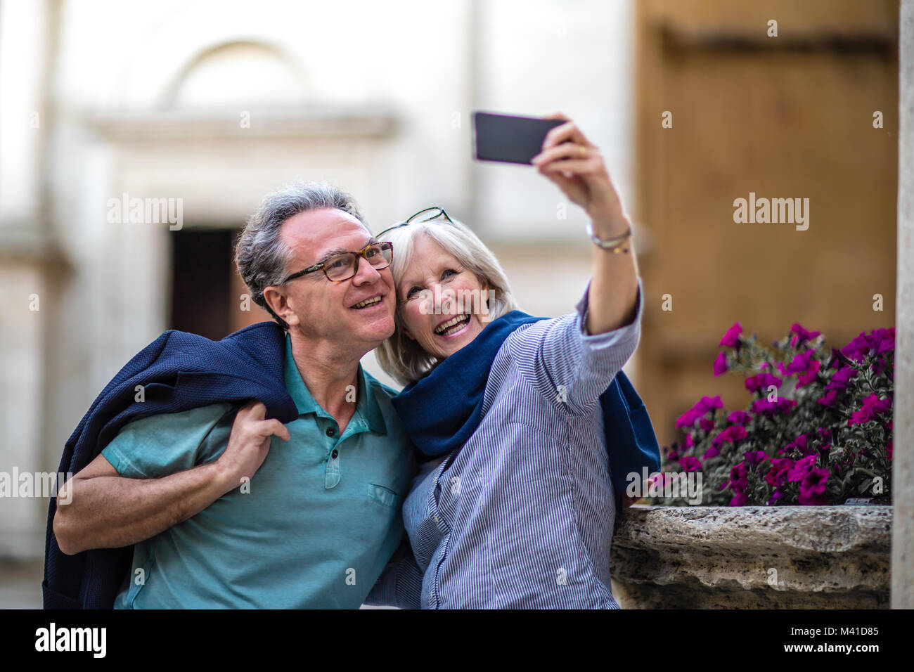 Senior couple on vacation taking a photo at a tourist site Stock Photo