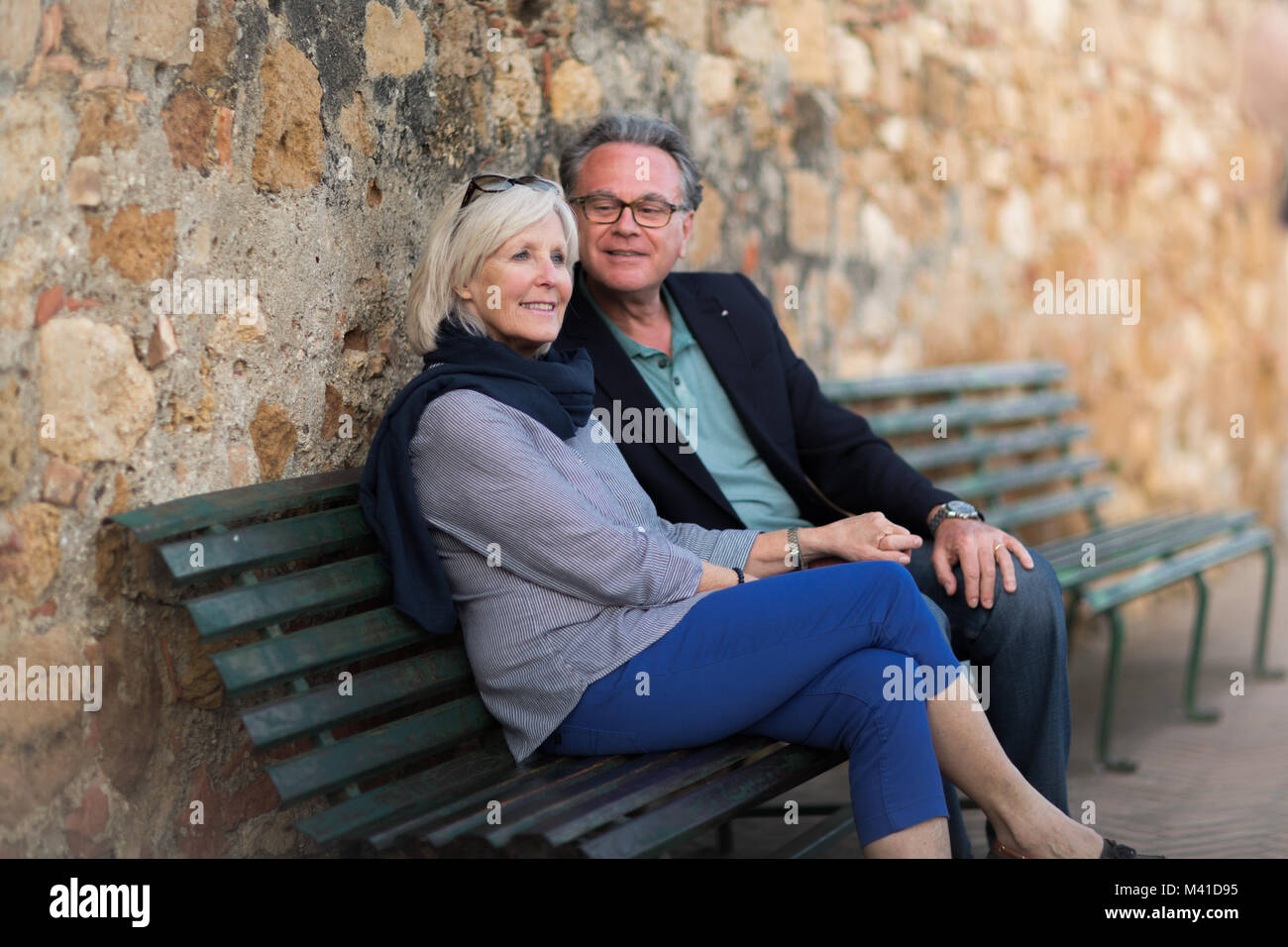 Senior couple sitting on bench relaxing Stock Photo