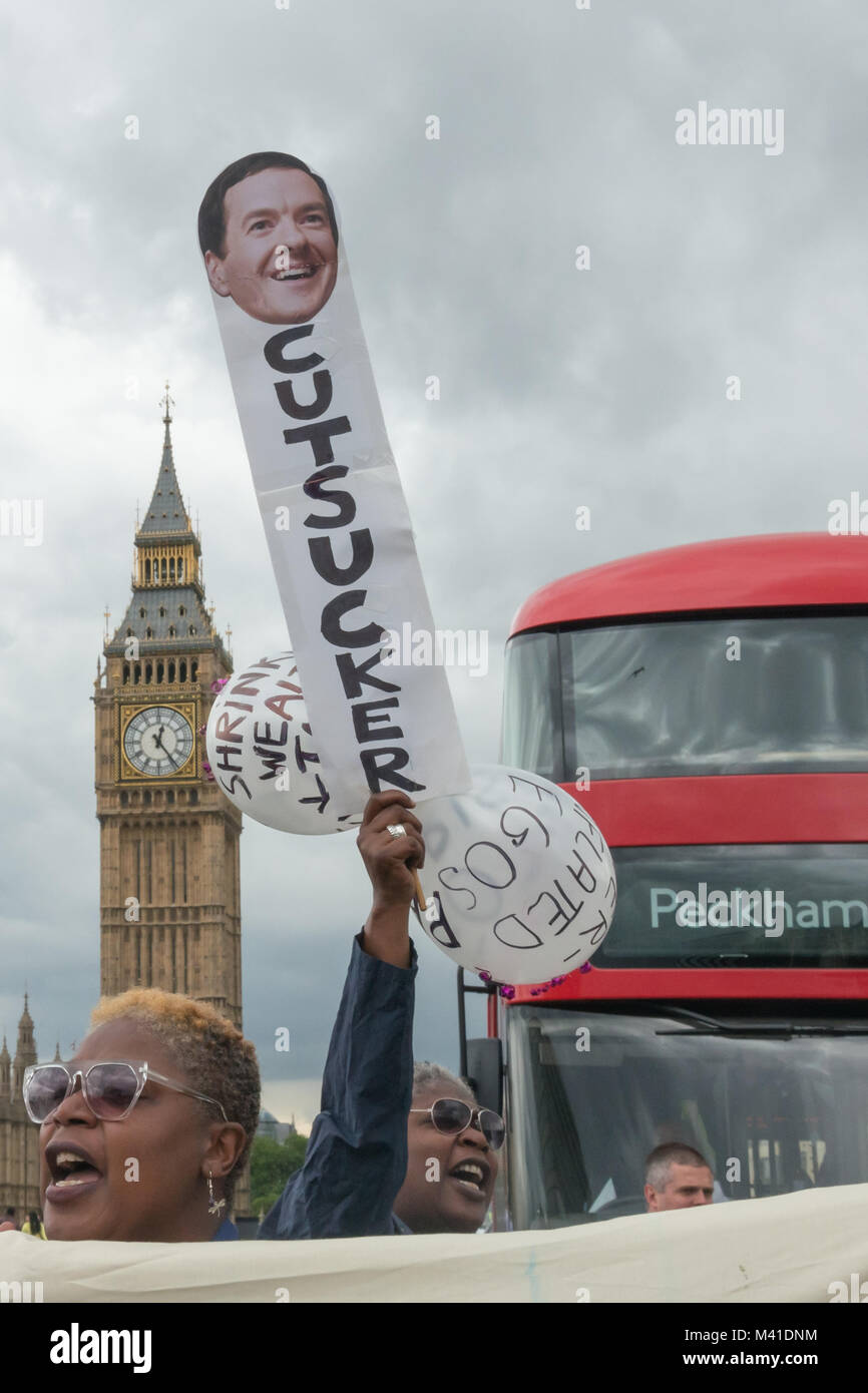 Women with a placard with a picture of George Osbone and the word 'CUTSUCKER' with two balloons behind the DPAC Banner blocking traffic on Westminster Bridge in fornt of Big Ben on Budget Day in protest against cuts hitting the disabled. Stock Photo