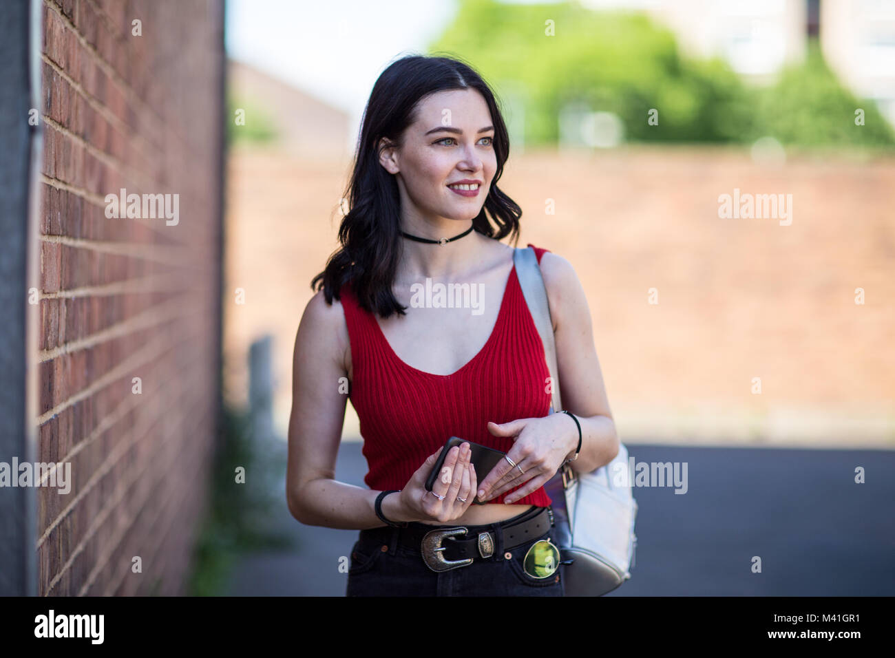 Young adult female turning to look at camera on street Stock Photo