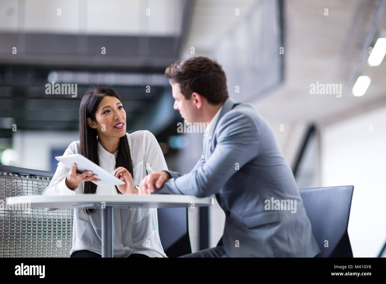 Colleagues in an informal business meeting using a digital tablet Stock Photo