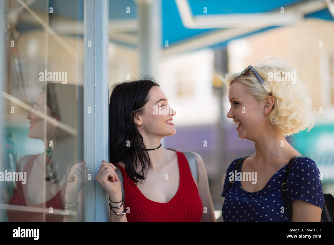 Female friends window shopping in summer Stock Photo