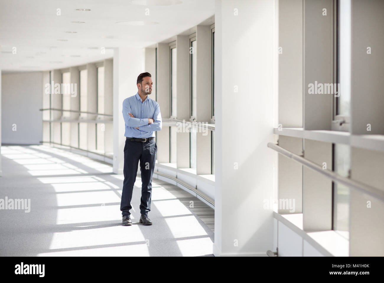Businessman looking out of window in office Stock Photo